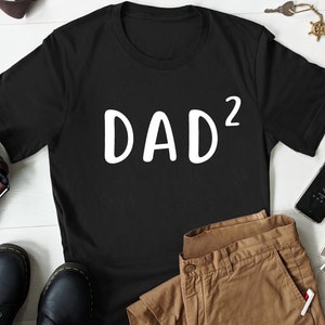May include: Black t-shirt with white text that reads "DAD²".