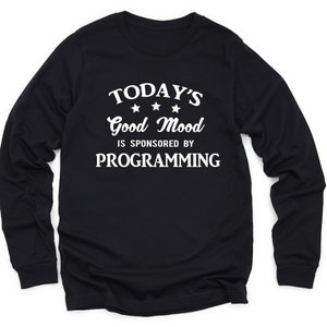 May include: Black long-sleeve t-shirt with white text that reads "TODAY'S Good Mood IS SPONSORED BY PROGRAMMING" with three white stars above the word "Good".