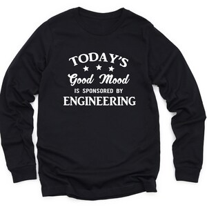 May include: Black long-sleeve t-shirt with white text that reads "TODAY'S Good Mood IS SPONSORED BY ENGINEERING" with three stars above the word "Good".