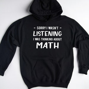 May include: Black hooded sweatshirt with white text that reads "Sorry I wasn't listening I was thinking about MATH".