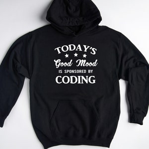 May include: Black hoodie with a white graphic that says "TODAY'S Good Mood IS SPONSORED BY CODING" with three stars above the word "Good".