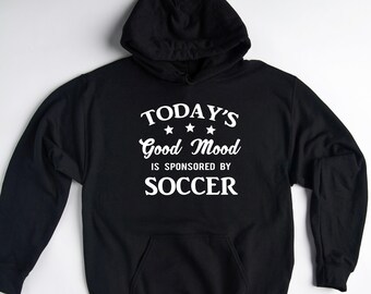 May include: Black hooded sweatshirt with white text that reads "TODAY'S Good Mood IS SPONSORED BY SOCCER" with three stars above the word "Good".