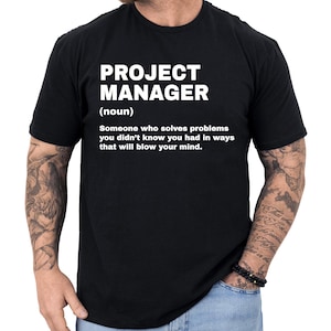 May include: Black t-shirt with the text "PROJECT MANAGER (noun) Someone who solves problems you didn't know you had in ways that will blow your mind." The text is in white, centered on the shirt.