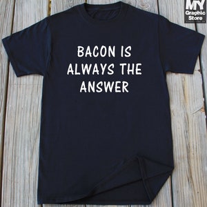 May include: Black t-shirt with white text that reads "Bacon is always the answer".