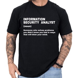 May include: Black t-shirt with the text "INFORMATION SECURITY ANALYST (noun) Someone who solves problems you didn't know you had in ways that will blow your mind." A humorous tee for IT professionals.