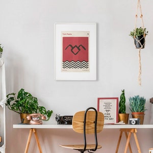 May include: A framed poster with a red background and a black silhouette of a bird with a black and white chevron pattern underneath. The poster is titled "Twin Peaks" and has the number "2" in the top right corner.
