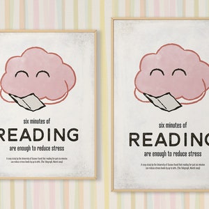 K&ouml;nnte beinhalten: Zwei gerahmte Poster mit hellem Holzrahmen. Jedes Poster zeigt eine rosa Wolke mit einem l&auml;chelnden Gesicht und einem Buch. Der Text lautet: "sechs Minuten LESEN reichen aus, um Stress abzubauen."