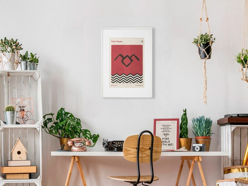 May include: A framed poster with a red background and a black silhouette of a bird with a black and white chevron pattern underneath. The poster is titled "Twin Peaks" and has the number "2" in the top right corner.
