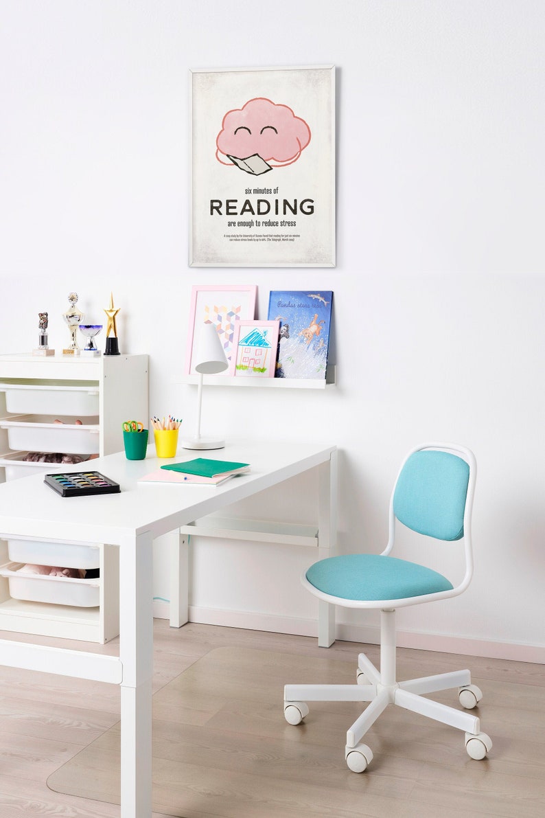 K&ouml;nnte beinhalten: Ein wei&szlig;er Schreibtisch und Stuhl in einem Raum mit einem Poster mit der Aufschrift "sechs Minuten LESEN reichen aus, um Stress abzubauen". Der Stuhl hat einen blauen Sitz und eine blaue R&uuml;ckenlehne. Weitere Artikel sind eine Lampe, B&uuml;cher und Kunstzubeh&ouml;r.
