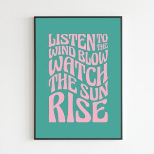 May include: A teal green poster with pink text that reads "Listen to the wind blow watch the sun rise".