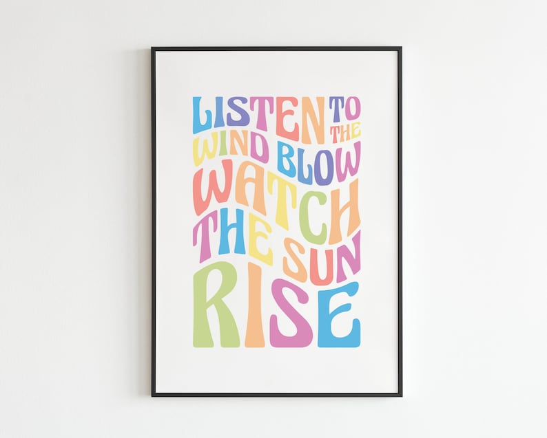 May include: A colorful typography print with the text "Listen to the wind blow watch the sun rise". The text is in a rainbow of colors, including pink, yellow, blue, green, and orange.