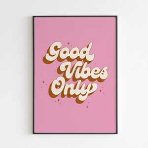 May include: A pink poster with the text "Good Vibes Only" in a retro font style. The text is in white with brown outlines. There are small white stars scattered around the text.