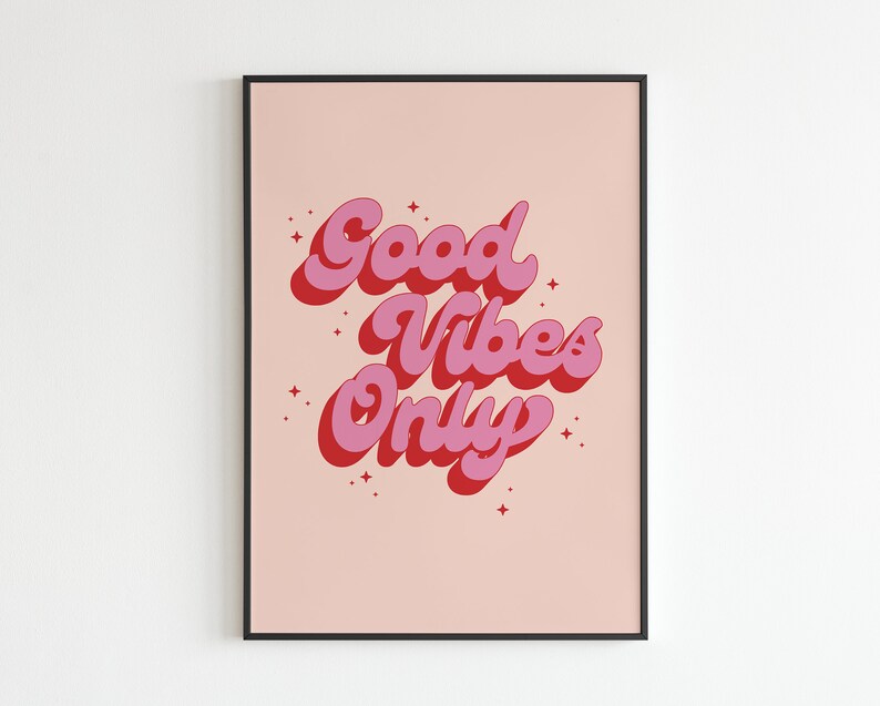 May include: A pink and red print with the text "Good Vibes Only" in a retro font style. The print is on a light pink background and is framed in a black frame.