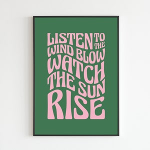 May include: A green poster with pink text that reads "Listen to the wind blow watch the sun rise".