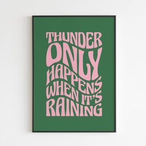 May include: A framed print with a green backdrop and pink text. The text reads "THUNDER ONLY HAPPENS WHEN IT'S RAINING" in a retro, wavy font. The frame is black.