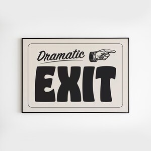 May include: A framed sign featuring the words "Dramatic EXIT" in bold black lettering. A pointing hand graphic is to the right of the word "Dramatic". The background is a light beige colour.