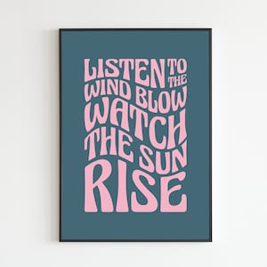 May include: A teal blue poster with pink text that reads "Listen to the wind blow watch the sun rise".