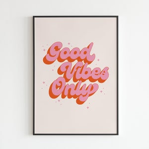May include: A framed print with a pink and orange retro-style graphic that says "Good Vibes Only" on a light pink background.