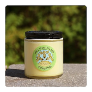 Może przedstawiać: Szklany słoik z czarną pokrywką i ż&oacute;łtą etykietą z napisem "Three Beautiful Bees All-Natural Beeswax Polish" z grafiką trzech pszcz&oacute;ł.