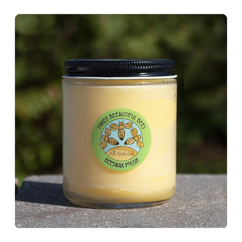 Może przedstawiać: Szklany słoik z pastą woskową z zielono-ż&oacute;łtą etykietą z napisem "Three Beautiful Bees All-Natural Beeswax Polish".