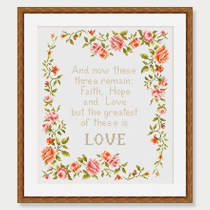 May include: A white cross-stitch embroidery with a floral border and the text "And now these three remain: Faith, Hope and Love but the greatest of these is LOVE".