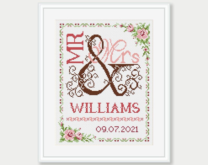 May include: Cross-stitch pattern with a brown and pink "Mr. & Mrs." design with a floral border and the text "WILLIAMS 09.07.2021".