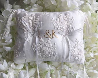 Peut inclure: Oreiller de mariage blanc brodé avec les lettres dorées "L&K" et des rubans de satin blancs. L'oreiller a des glands blancs à chaque coin.