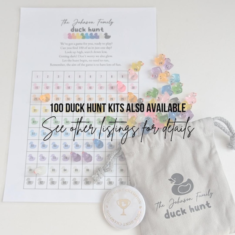 May include: A printed game sheet with a grid and the text "The Johnson Family duck hunt". Includes a small drawstring bag, a button, and colorful duck-shaped game pieces. The text "100 DUCK HUNT KITS ALSO AVAILABLE" is also visible.