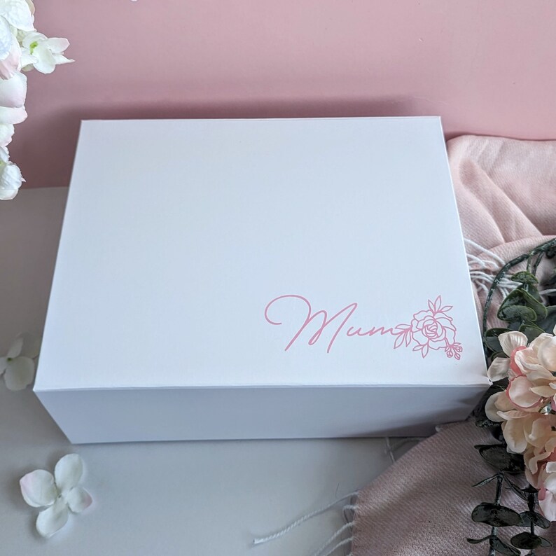 May include: White gift box with a pink floral design and the word "Mum" written in cursive.