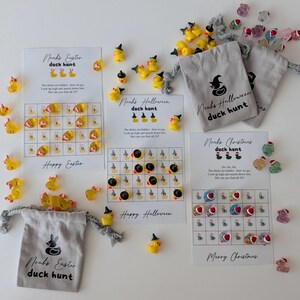 May include: A collection of duck hunt game sets for Easter, Halloween, and Christmas. Each set includes a game card with a grid, small duck figurines, and a drawstring bag. The text "Noah's Easter duck hunt", "Noah's Halloween duck hunt", and "Noah's Christmas duck hunt" is visible.