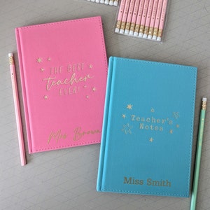 May include: Two personalised notebooks, one pink and one blue. The pink notebook says "The Best Teacher Ever!" with a gold star design and "Miss Brown" at the bottom. The blue notebook says "Teacher's Notes" with a gold star design and "Miss Smith" at the bottom.