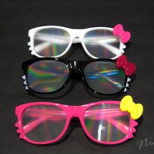 May include: Three pairs of sunglasses with iridescent lenses and colorful bow accents. The top pair is white with pink bows, the middle pair is black with red bows, and the bottom pair is pink with yellow bows.