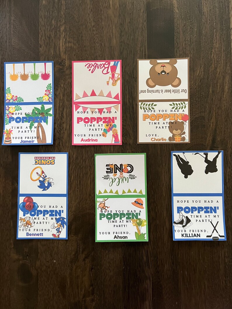 May include: Ten colourful thank you cards with a pop-up theme. Each card features a different character or design, including a dinosaur, a bear, a monkey, a hockey player, and a Barbie doll. The cards have the text "Hope you had a poppin' time at my party!" and a personalised message from the host.