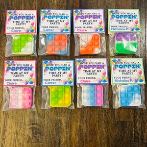May include: Eight favour bags with colourful pop-it fidget toys and a tag that says "Hope you had a poppin' time at my party!" with the name of the party host.