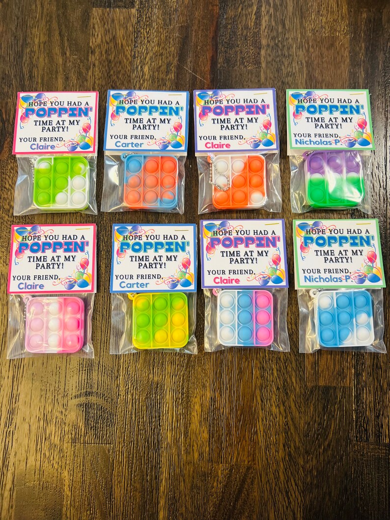 May include: Eight favour bags with colourful pop-it fidget toys and a tag that says "Hope you had a poppin' time at my party!" with the name of the party host.