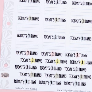 May include: A sheet of white paper with 18 blank labels. Each label has the text "TODAY'S 1 THING" printed on it in black. The labels are arranged in a grid of six rows and three columns. The labels are decorated with small yellow stars.
