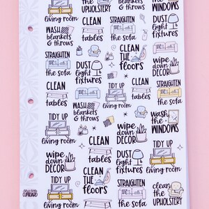 May include: A sheet of planner stickers with various cleaning tasks, including "Tidy Up," "Clean the Floors," and "Wash the Windows." The stickers feature illustrations of furniture and cleaning tools, with text in a handwritten style. The text "let's clean the living room" is also present.