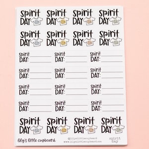 May include: A sheet of white stickers with black text and illustrations. The stickers say "Spirit Day" and feature a cartoon illustration of a t-shirt with the text "Wacky Spirit Day" on it. The stickers are designed for a school or classroom setting.