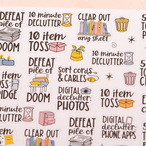 May include: A sheet of colourful stickers with various decluttering tasks. The stickers feature illustrations of a bin, a pile of clothes, a box, a cord, a camera, and a phone. The text on the stickers includes "DEFEAT pile of DOOM", "10 minute DECLUTTER", "10 item TOSS", "5 item TOSS", "CLEAR OUT any shelf", "Sort cords & CABLES", "DIGITAL declutter: PHOTOS", "DIGITAL declutter: PHONE APPS", "EDIT crafts", "5 item TOSS: PANTRY", "5 item TOSS: CLOSET", "5 item TOSS: FRIDGE", "5 item TOSS: FRIDGE".
