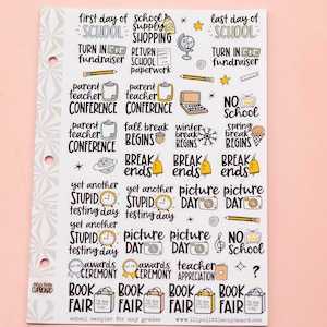May include: A sheet of colorful stickers with illustrations and text related to school events. The stickers feature phrases like "first day of school", "last day of school", "parent teacher conference", "fall break begins", "picture day", "awards ceremony", and "book fair".