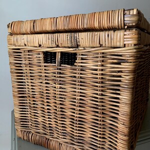 Peut inclure: Un panier de rangement rectangulaire en osier avec un couvercle. Le panier est tiss&eacute; en rotin brun clair et comporte une petite ouverture rectangulaire sur le devant. Le couvercle est &eacute;galement en rotin tress&eacute;.