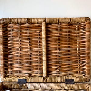 Peut inclure: Un panier rectangulaire en osier avec un couvercle &agrave; charni&egrave;re, ouvert pour r&eacute;v&eacute;ler l'int&eacute;rieur. Le panier est fait d'osier brun et beige tiss&eacute;, avec des charni&egrave;res m&eacute;talliques. Le couvercle est l&eacute;g&egrave;rement entrouvert.
