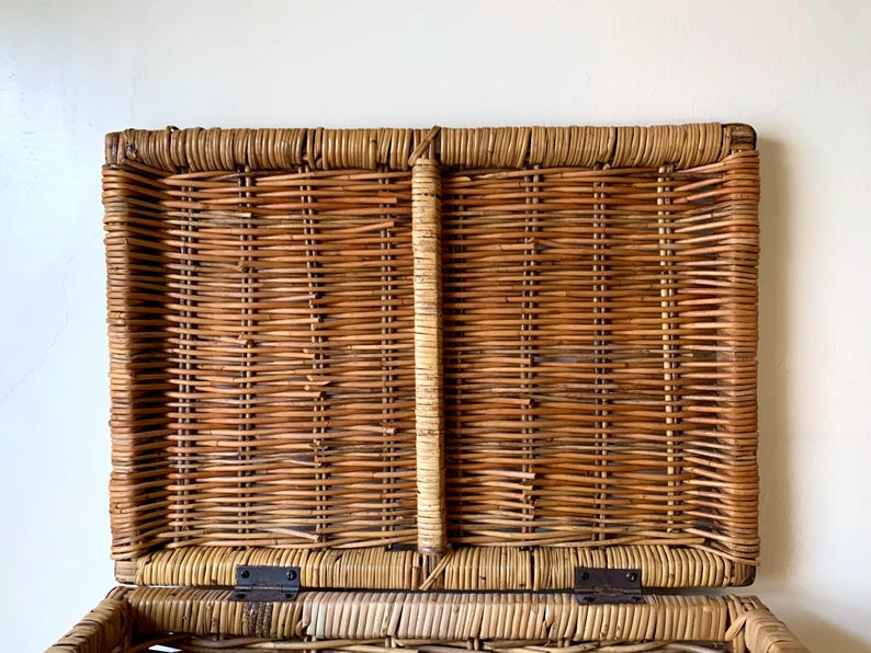 Peut inclure: Un panier rectangulaire en osier avec un couvercle &agrave; charni&egrave;re, ouvert pour r&eacute;v&eacute;ler l'int&eacute;rieur. Le panier est fait d'osier brun et beige tiss&eacute;, avec des charni&egrave;res m&eacute;talliques. Le couvercle est l&eacute;g&egrave;rement entrouvert.