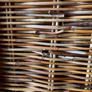 Peut inclure: Gros plan sur un panier en osier tress&eacute;. Le panier est fait de roseaux naturels de couleur marron clair et beige. Les roseaux sont tiss&eacute;s horizontalement et verticalement, cr&eacute;ant une surface textur&eacute;e. Le tissage est serr&eacute; et le panier semble robuste.