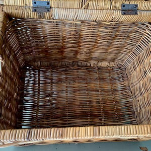 Peut inclure: Panier en osier ouvert avec couvercle &agrave; charni&egrave;re. Fabriqu&eacute; en osier tiss&eacute; brun clair et fonc&eacute;. Le couvercle est fix&eacute; par des charni&egrave;res m&eacute;talliques. Le panier est rectangulaire avec des coins arrondis et des poign&eacute;es sur les c&ocirc;t&eacute;s.