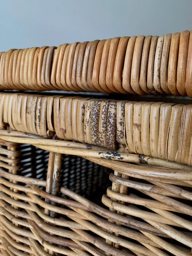 Peut inclure: Gros plan sur un panier en osier tress&eacute; de couleur marron clair naturelle. Le panier pr&eacute;sente une surface textur&eacute;e avec des motifs tiss&eacute;s verticaux et horizontaux. Le bord a un design arrondi et nervur&eacute;. Certaines zones montrent des signes d'&acirc;ge et d'usure.