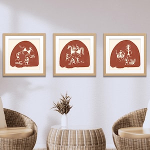 May include: Three framed prints of red and white tribal art depicting figures and animals. The prints are in wooden frames and are hung on a white wall.