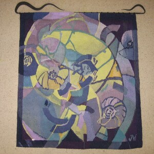 Puede incluir: Tapiz abstracto con un patrón de remolino en tonos de morado, azul, amarillo y verde. El tapiz está tejido con una variedad de texturas y tiene un fondo oscuro.