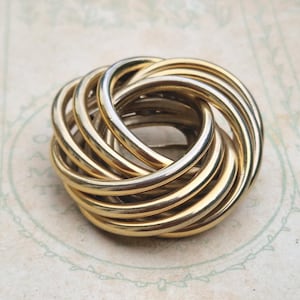 Vintage guldfärgad kärleksknutbrosch – Modern sammankopplade ringdesign från mitten av århundradet (ca 1950–1970-talet)
