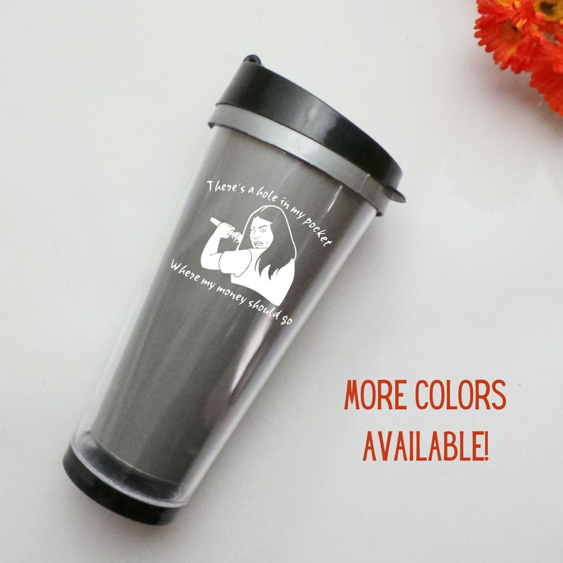 K&ouml;nnte beinhalten: Eine silberne Reise-Trinkflasche mit einer wei&szlig;en Grafik einer Frau, die ein Mikrofon h&auml;lt, und dem Text "There's a hole in my pocket where my money should go". Der Text "MORE COLORS AVAILABLE!" ist in Rot unter der Grafik gedruckt.